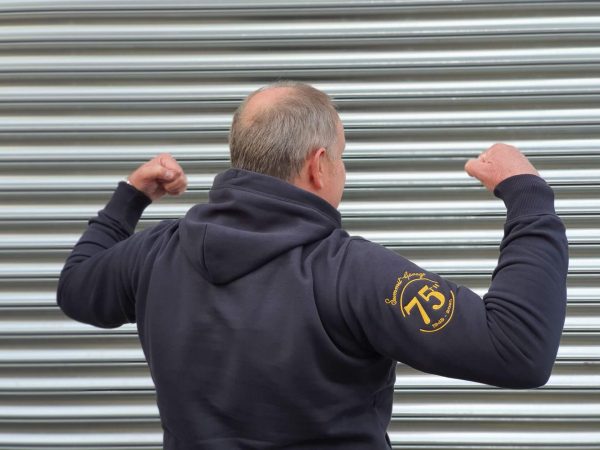 John flexing his muscles in the Limited Edition ‘75th Anniversary’ Hooded Sweatshirt